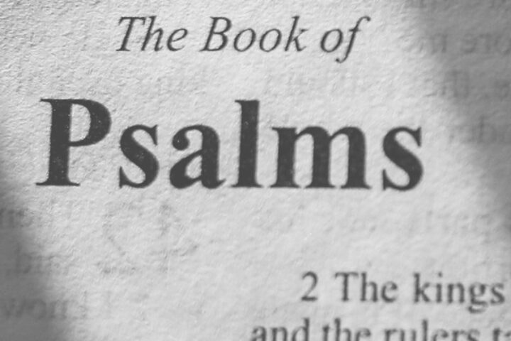 Page showing the title 'The Book of Psalms' with 'BOOK I' and column text visible, in grayscale with a light shadow across the page.